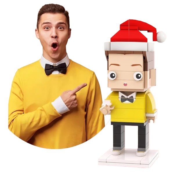 Man in yellow sweater pointing at a LEGO figure with a Santa hat on a pink background