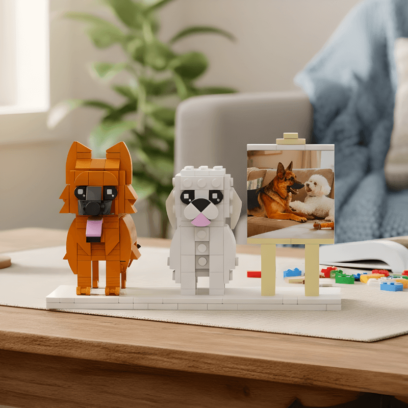 Two dog-shaped lego figures on a table with a photo of dogs in the background.