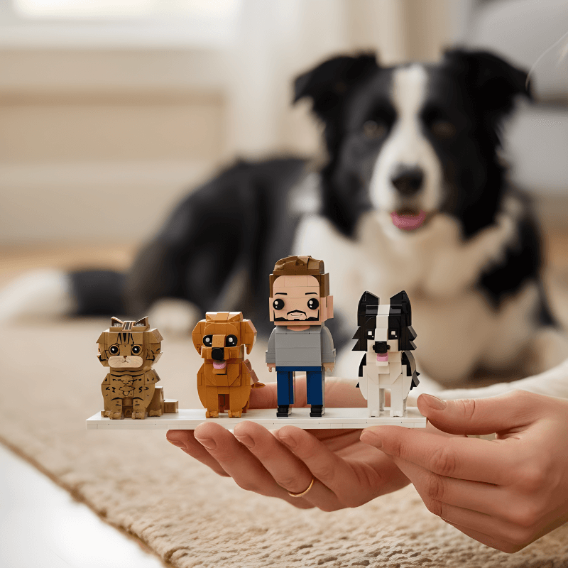 Person holding a small figurine of a man with a dog, with a real dog in the background.