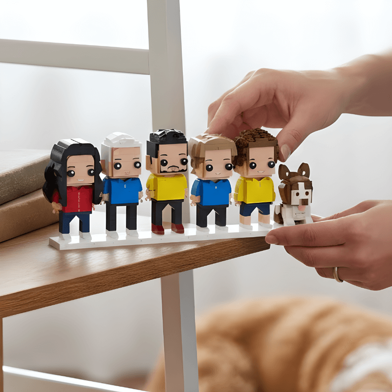 Set of small lego figurines on a stand with a hand interacting with them, on a wooden surface.