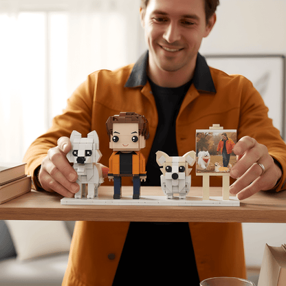 Man holding LEGO-style figures of a person and a dog on a wooden table.