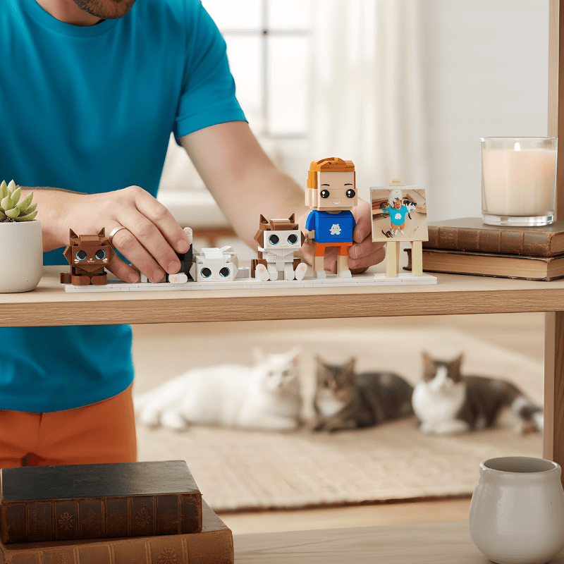 Person playing with small custom brick figurines set on a table with cats in the background
