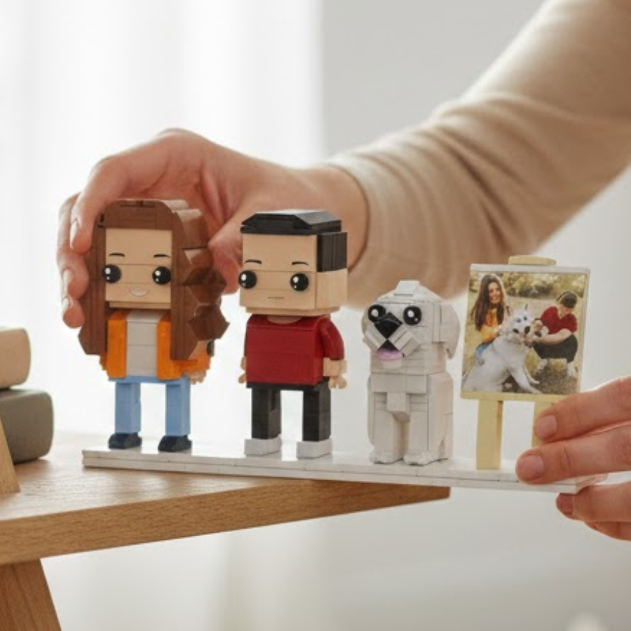 Person holding a display with small brick figurines and a photo of a dog and person.