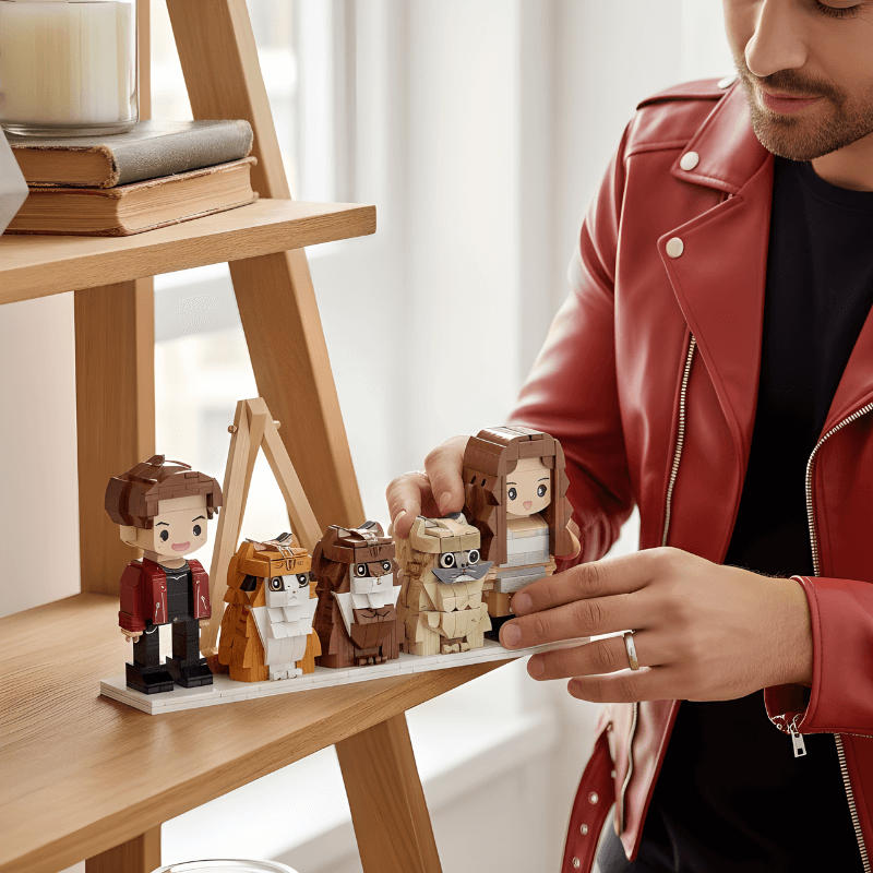 Person in a red jacket arranging small custom brick figurines on a wooden shelf.