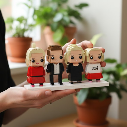 Four small custom brick figurines on a stand held by a person with plants in the background