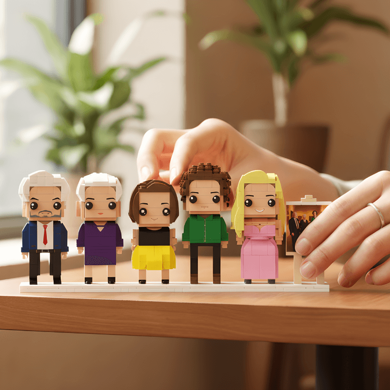 Set of custom mini figurines on a wooden surface with a hand interacting with them.
