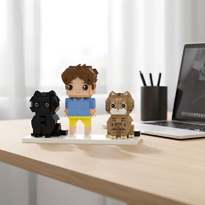 Custom mini figurines cat and owner on a desk with a laptop in the background