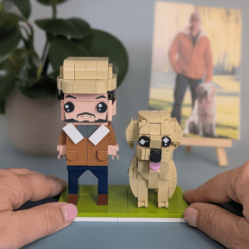 Hand holding a LEGO-style figure of a man with a dog on a small platform, custom mini figure