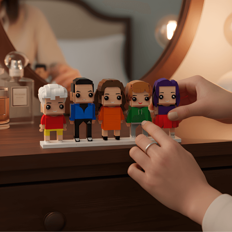 Set of mini figurines on a stand with a hand interacting with them, on a wooden surface.