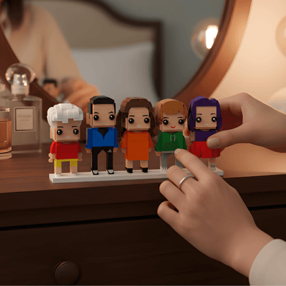 Set of mini figurines on a stand with a hand interacting with them, on a wooden surface.