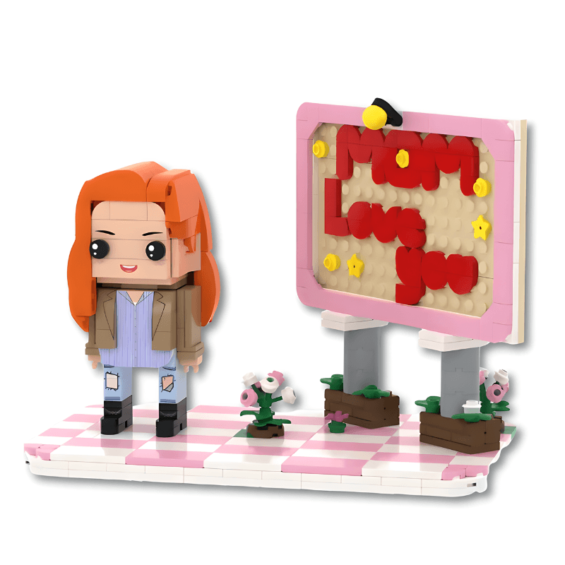 Toy figure with red hair and a sign saying 'Mom Love You' on a checkered platform.