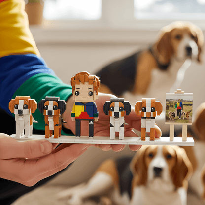 Hand holding a set of custom mini figures with dogs and a person, with a dog in the background.