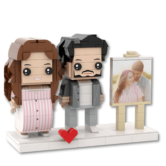 Brick-built figures of a couple with a heart and a photo display on a white background
